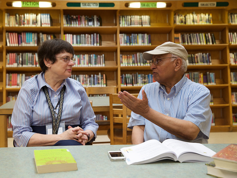 A library volunteer working with a patron